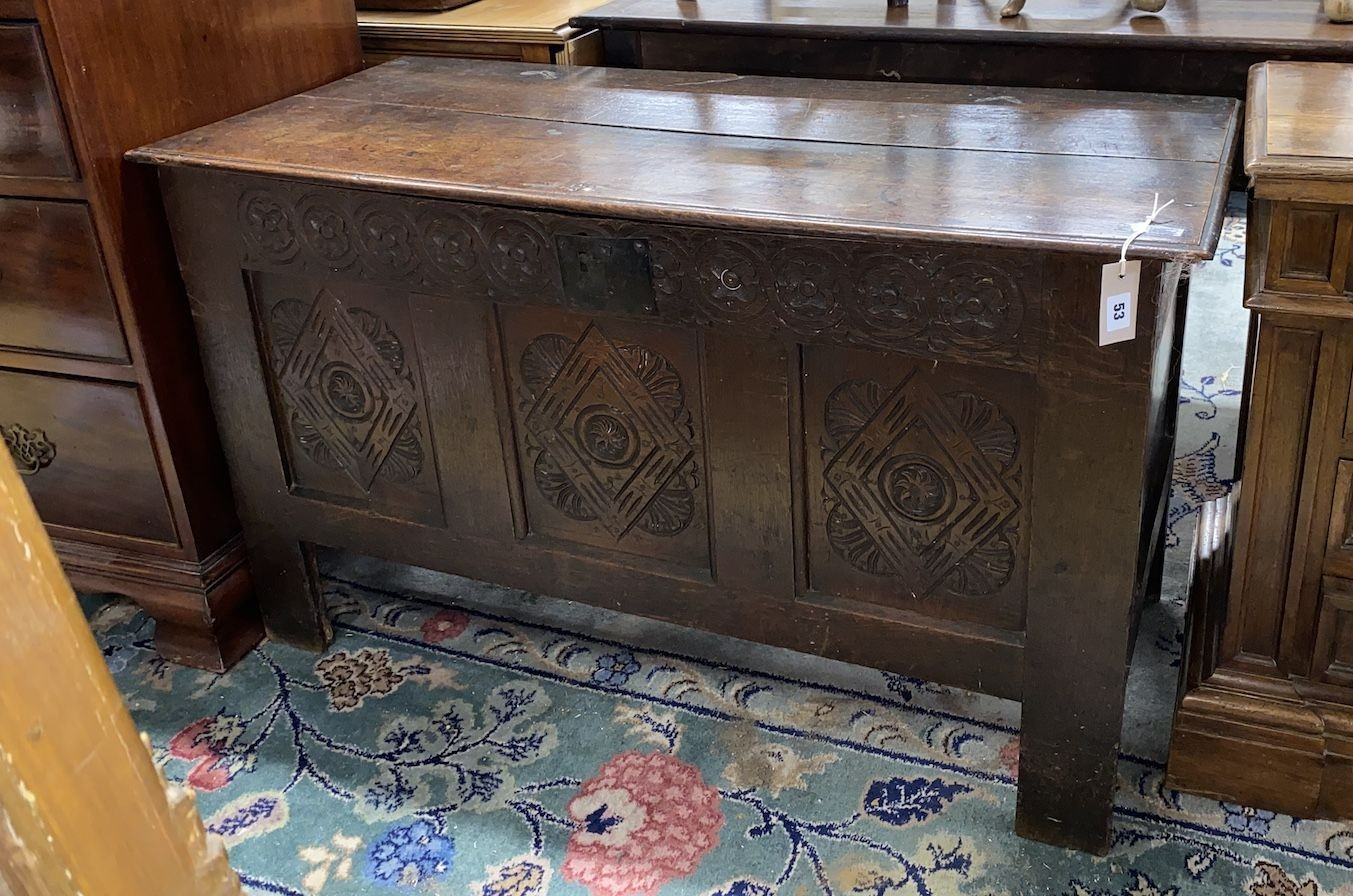 An 18th century carved panelled oak coffer, lid in two sections, length 115cm, depth 50cm, height 66cm